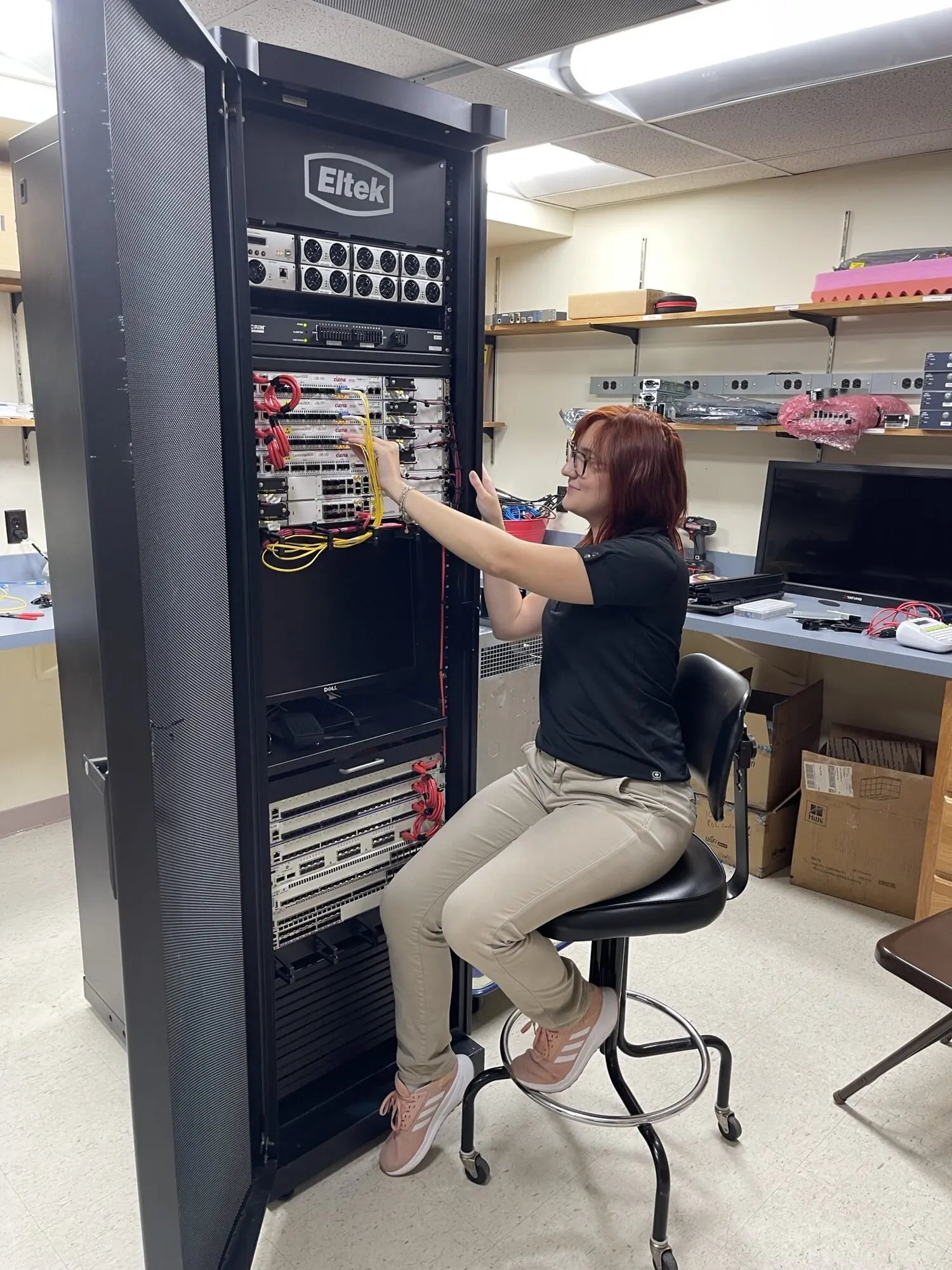 Woman working on network server rack.