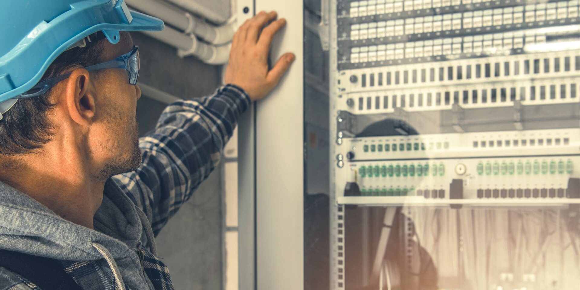Electrician inspecting server rack equipment.