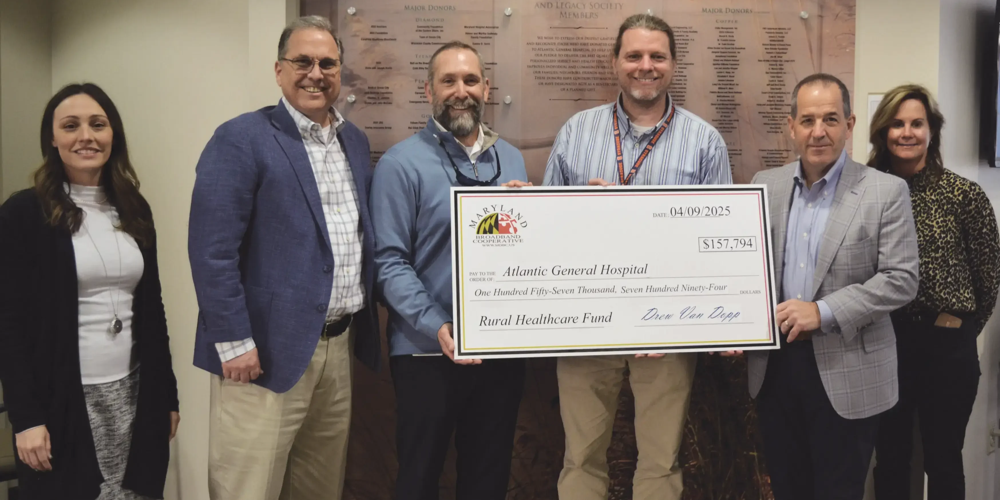 A Group Of People With A Large Cheque